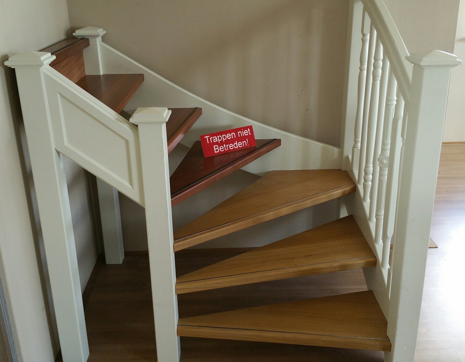Houten trap met witte balustrade als voorbeeld van trap op maat